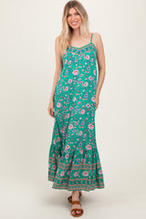 woman wearing a green floral maxi dress with spaghetti straps and a ruffled hem