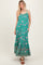 woman wearing a green floral maxi dress with spaghetti straps and a ruffled hem