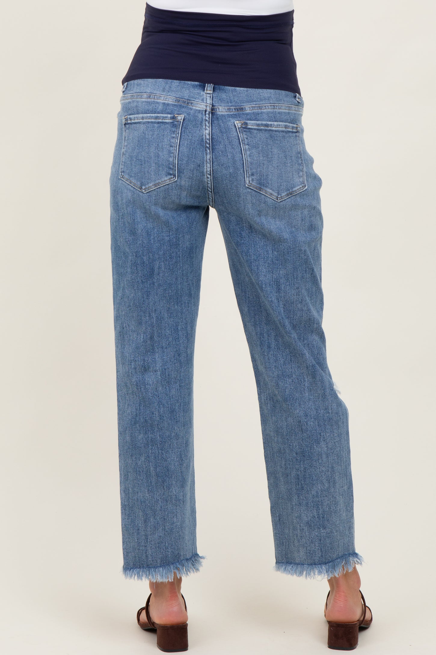 maternity wear light blue high-waisted jeans with a frayed hem, shown from the back