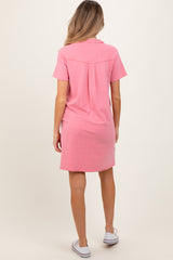 woman wearing a short sleeve pink maternity dress with a back pleat detail