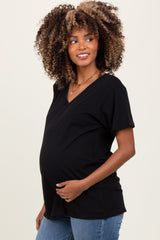 woman wearing a black short sleeve maternity top and displaying her baby bump