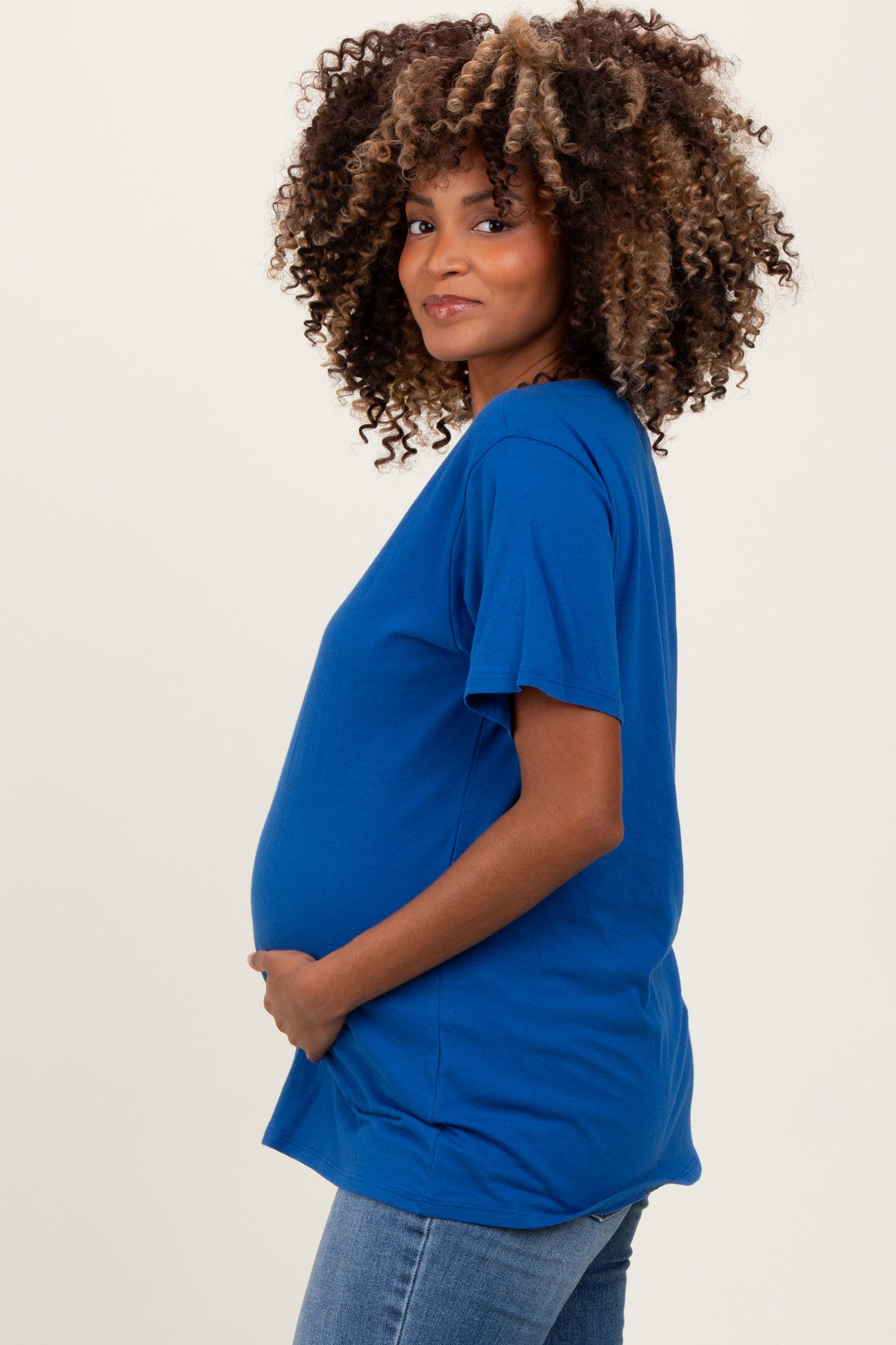 woman wearing a blue short sleeve maternity shirt and holding her baby bump