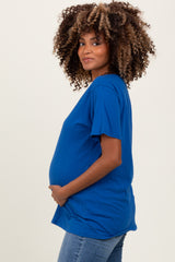 woman wearing a blue short sleeve maternity shirt and holding her baby bump