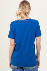 woman wearing a bright blue short sleeve t-shirt, seen from the back, paired with light blue jeans