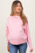 woman wearing a light pink maternity sweatshirt with a relaxed fit and visible baby bump