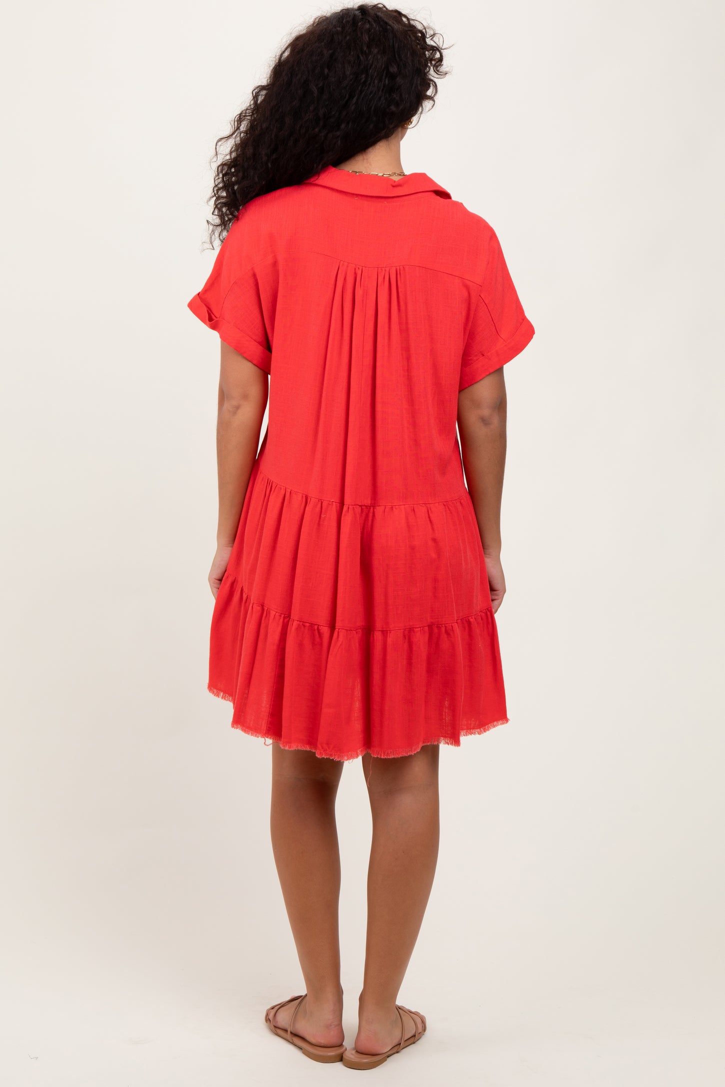 woman wearing a red short sleeve tiered dress with a relaxed fit and a gathered back detail