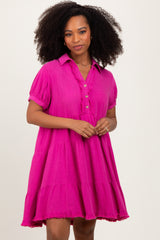 woman wearing a bright pink short sleeve dress with a collar, button-up front, and tiered skirt details
