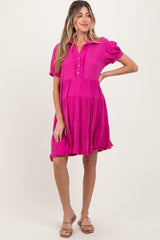 woman wearing a hot pink short sleeve maternity dress with buttons and a tiered skirt, showing her baby bump