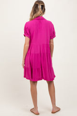 woman wearing a vibrant pink short sleeve maternity dress with a tiered hem, showing her baby bump from the back