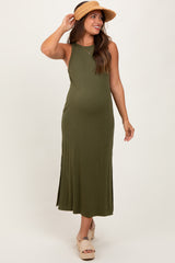 woman wearing an olive green maternity maxi dress with side slits and a sun hat, showcasing her baby bump
