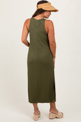 woman wearing a dark green maternity maxi dress with a heart detail on the back and side slits