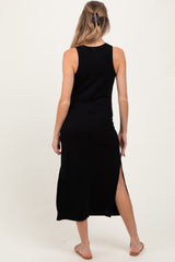 woman wearing a black sleeveless maternity dress with a side slit, showing her back and long hair