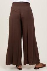 woman wearing brown maternity palazzo pants with a smocked waist from the back
