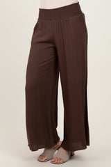 woman wearing brown high-waisted wide-leg pants with a smocked waistband