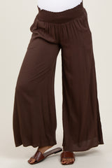 woman wearing dark brown maternity wide-leg pants with a smocked waistband and a relaxed fit