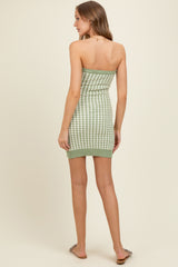 woman wearing a green and white checkered strapless knit maternity dress