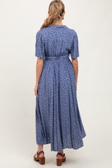 woman wearing a blue floral maternity maxi dress with a cinched waist, seen from the back