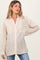 woman wearing a striped maternity shirt in beige and white, paired with blue jeans and showing a baby bump