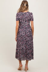 woman wearing a floral print maternity maxi dress with short sleeves and a flowing skirt