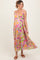 woman wearing a colorful floral maternity maxi dress with a pleated design and a visible baby bump
