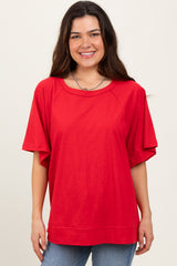 woman wearing a red oversized short sleeve t-shirt with a round neckline and relaxed fit, smiling at the camera