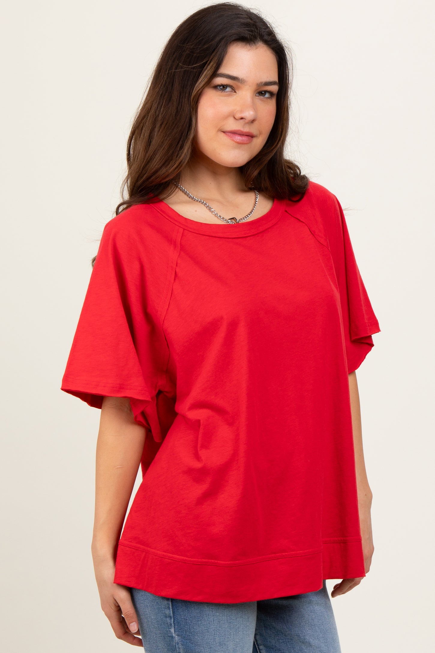 woman wearing a red oversized t-shirt with short sleeves and a relaxed fit