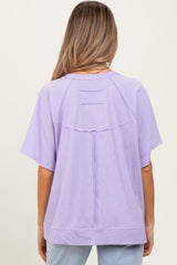 woman wearing a lilac maternity top with a relaxed fit and unique back detail