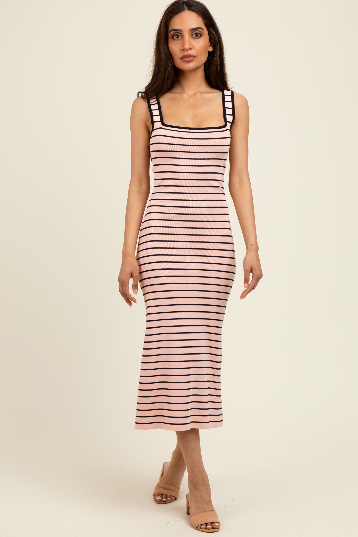 woman wearing a pink and black striped midi dress with a square neckline and fitted style