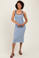 woman wearing a light blue striped midi dress with black trim and spaghetti straps