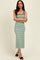 woman wearing a green and white striped midi dress with a square neckline and fitted silhouette