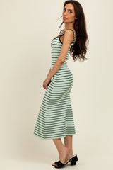 woman wearing a mint green and black striped midi dress with a fitted silhouette and spaghetti straps