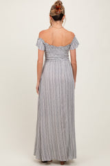 woman wearing a striped off-the-shoulder maxi maternity dress, showing the back view and flowing skirt