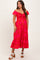 woman wearing a hot pink floral off-shoulder maternity dress with a smocked bodice and ruffle hem, showing her baby bump