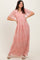 woman wearing a blush pink maxi dress with floral embroidery and short sheer sleeves, posed with hands on hips
