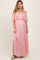 woman wearing a light pink off-the-shoulder maternity maxi dress with floral lace details and a visible baby bump