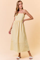 woman wearing a yellow and white striped maxi dress with thin straps and a gathered waist