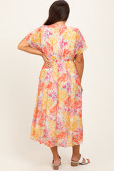 woman wearing a colorful floral maternity maxi dress with short sleeves and an elastic waistband, showing a baby bump