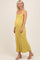 woman wearing a yellow striped maternity dress, showcasing her baby bump, standing against a neutral background