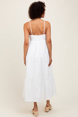 woman wearing a white maxi dress with a smocked bodice and tiered skirt, seen from the back