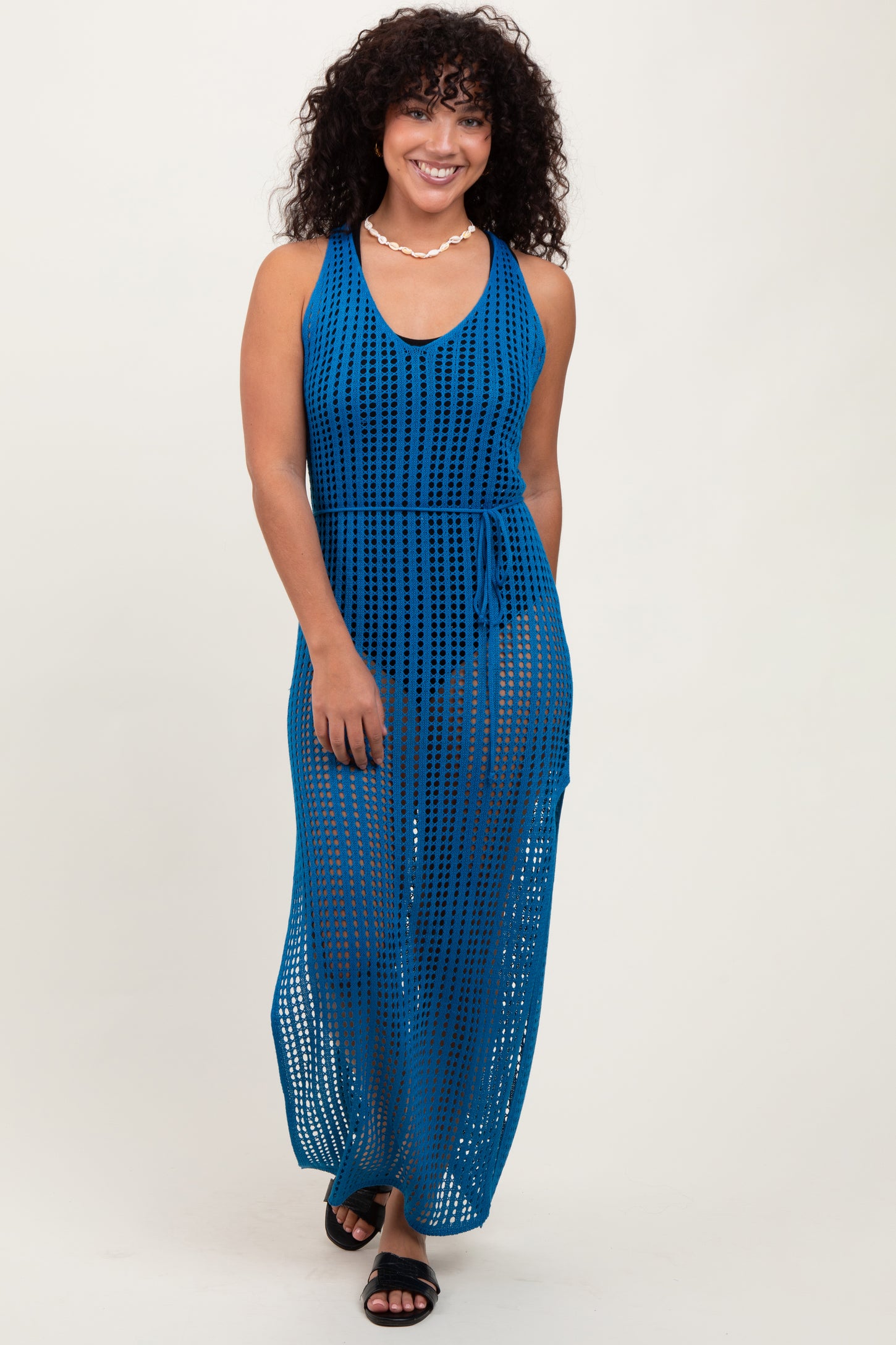 woman wearing a deep blue open-knit maxi dress with a tie waist and a v-neckline
