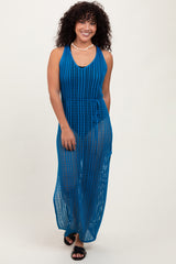 woman wearing a deep blue open-knit maxi dress with a tie waist and a v-neckline