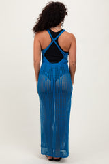 woman wearing a blue open knit long maxi dress with a black tank top underneath, view from the back
