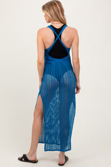 woman wearing a blue open-knit maternity cover-up dress with side slits, showing a black top underneath and a baby bump