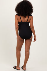woman wearing a black ribbed one-piece swimsuit with adjustable straps, viewed from the back