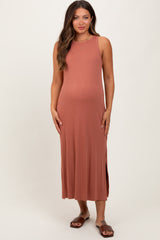 woman wearing a rust-colored sleeveless maternity dress with side slits and a visible baby bump