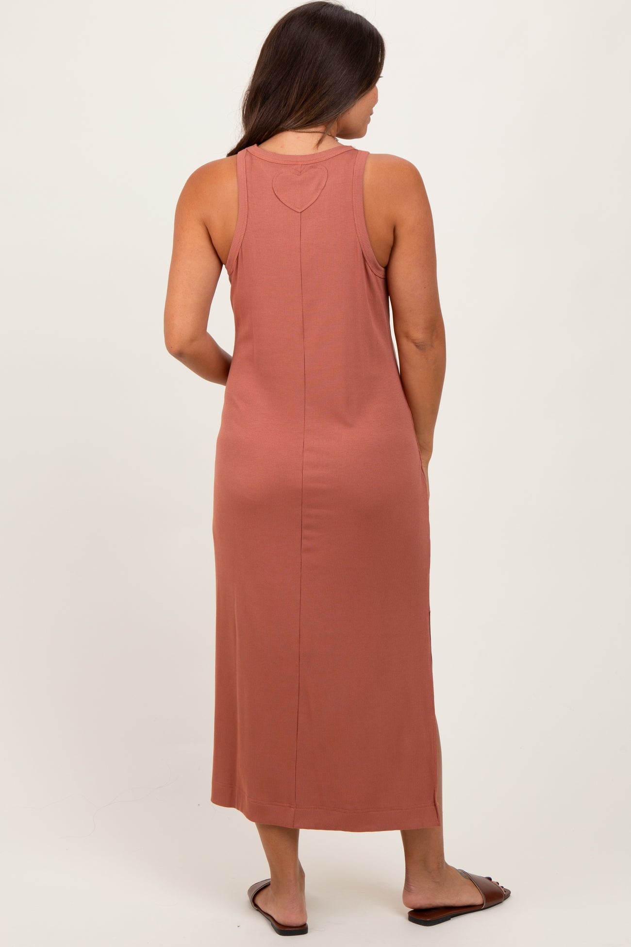 woman wearing a rust-colored ribbed maternity maxi dress viewed from the back