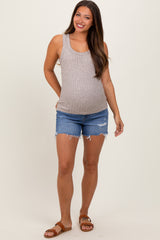 woman wearing a light gray ribbed maternity tank top and distressed denim shorts, showing her baby bump