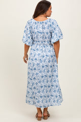 woman wearing a blue and white floral patterned maternity dress with puff sleeves and a smocked waist