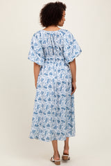woman wearing a blue and white floral maxi dress with short flutter sleeves and a smocked bodice, viewed from the back