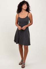 woman wearing a black and white striped spaghetti strap dress with a flared skirt and strappy sandals
